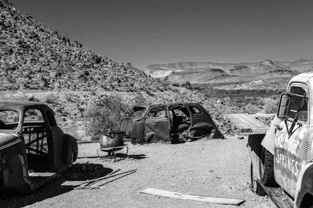 Black-and-white photo desert ridge and rusting vehicle near Cool Springs Station Route 66 Arizona