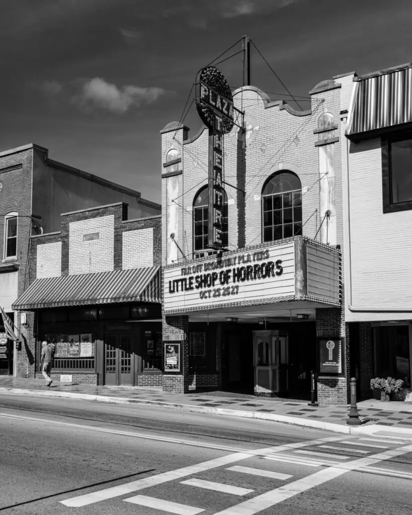 Black-and-white photo of the Plaza Theatre façade at 115 East Main Street, Glasgow, Kentucky, showing the vertical marquee sign and entrance.